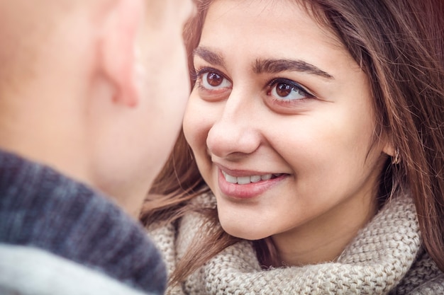 Una ragazza con gli occhi belli guarda il suo fidanzato. Giovani felici Avvicinamento. Il concetto di amore.