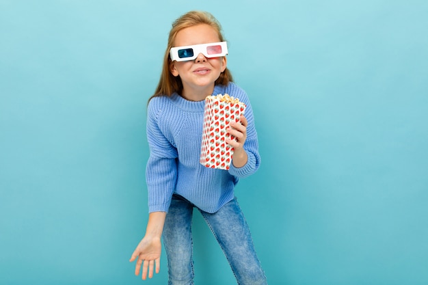 Una ragazza con il trucco e lunghi capelli castani, occhiali 3d sembra film o cartone animato con popcorn