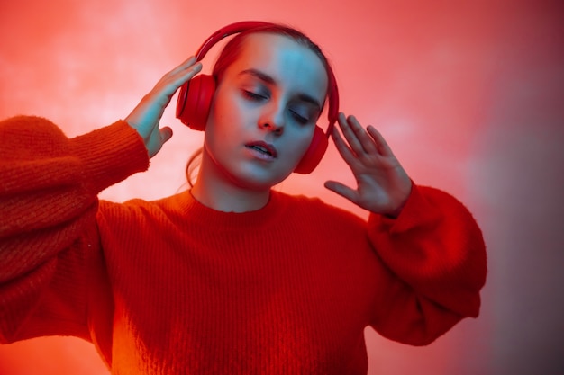 Una ragazza con luci colorate ascolta musica con le cuffie