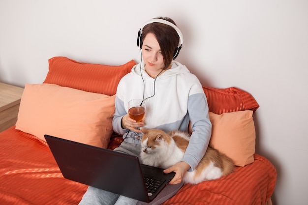 Una ragazza con un bicchiere di vino comunica online con amici e parenti