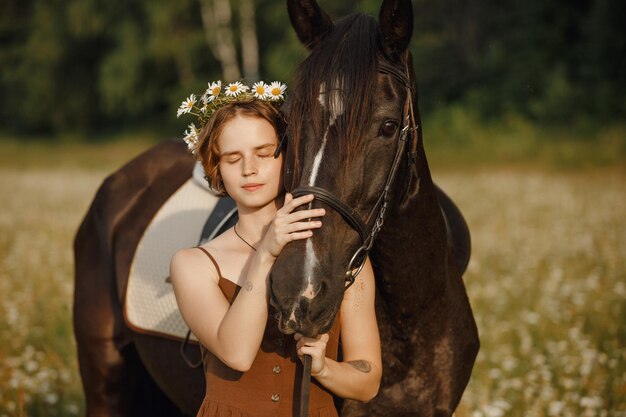 Una ragazza con un cavallo un vestito marrone un uomo in natura con un animale