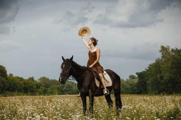 Una ragazza con un cavallo un vestito marrone un uomo in natura con un animale