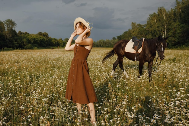 Una ragazza con un cavallo un vestito marrone un uomo in natura con un animale