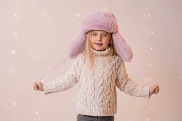 Una ragazza con un maglione bianco e un cappello rosa