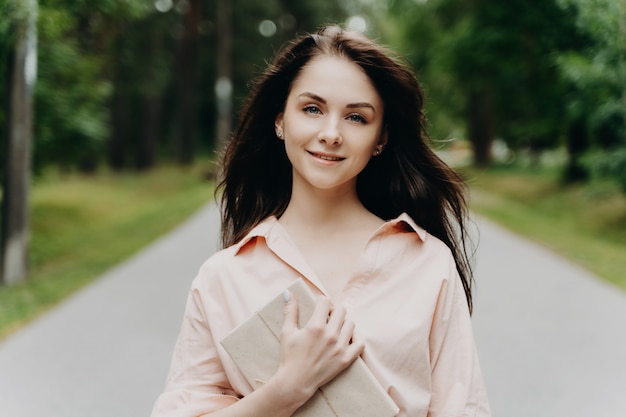 Una ragazza con un regalo cammina nel parco