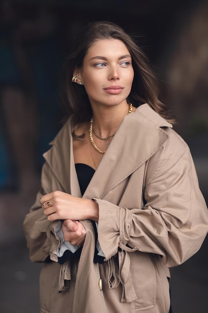 Una ragazza con un trench alla moda passeggia nel centro storico