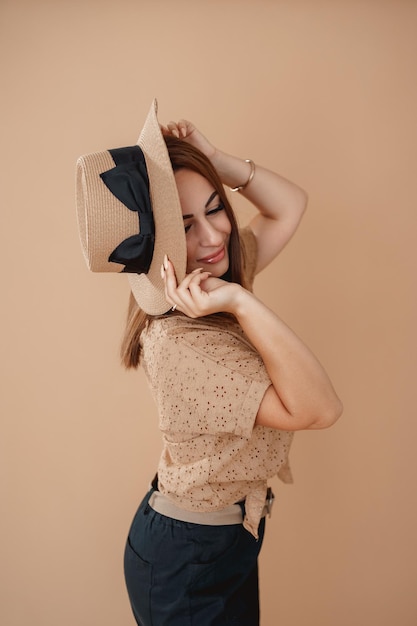 una ragazza con una camicia beige su fondo beige