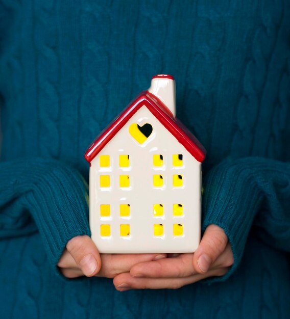 Una ragazza con una casa tra le mani