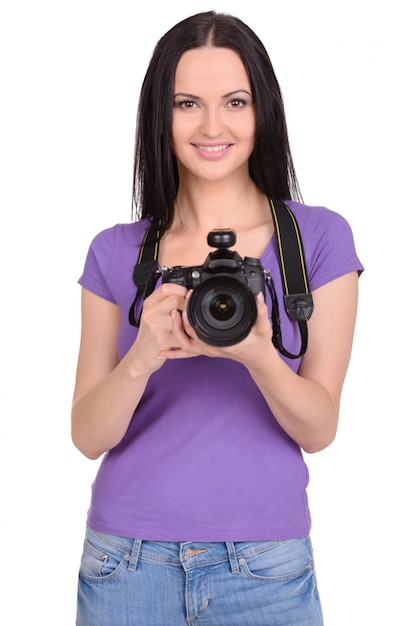 Una ragazza con una macchina fotografica è in piedi su un bianco.