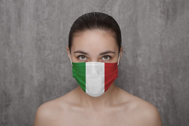 Una ragazza con una maschera sul viso con la bandiera dell'Italia