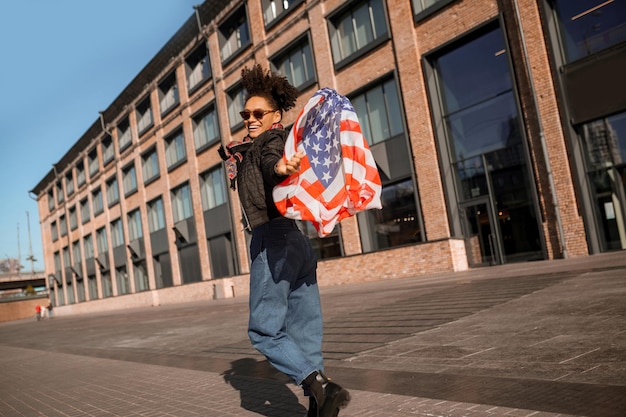 Una ragazza dalla pelle scura con la bandiera americana in mano