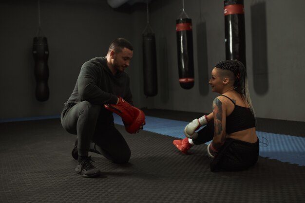 Una ragazza disabile è impegnata in palestra Una donna con una gamba sola si allena con un trainer, lavora sodo e non si arrende davanti ai guai