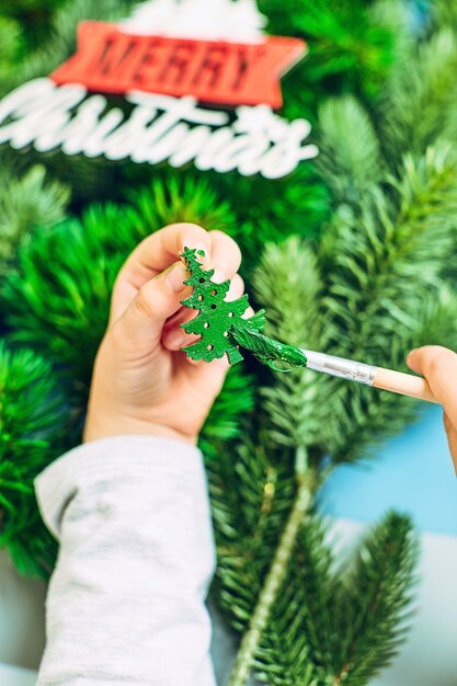 Una ragazza disegna un albero di Natale, preparandosi per il nuovo anno 2022. Buon Natale e felice anno nuovo concept