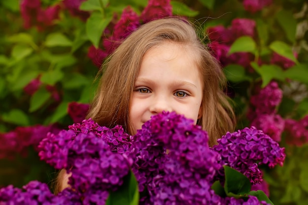 Una ragazza è circondata da fiori viola e la parola lilla è sulla parte anteriore del suo viso.