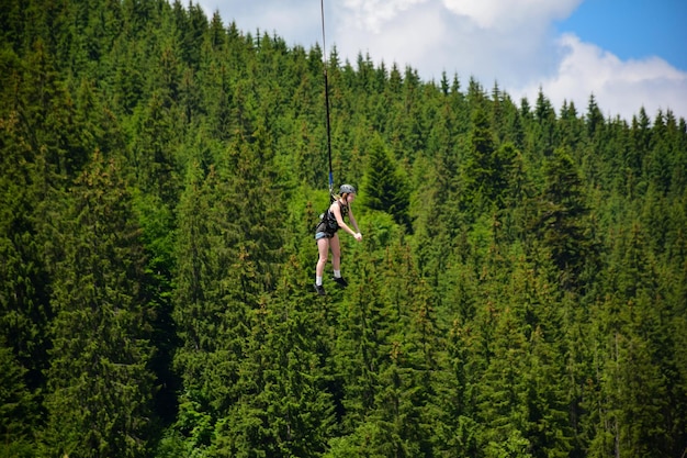 Una ragazza è saltata da una corsa di bungee jumping appesa a una corda tesa ad alta quota e sorride