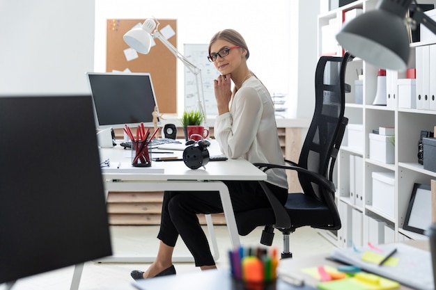 Una ragazza è seduta alla scrivania del computer in ufficio.