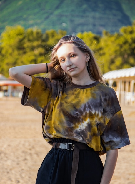 Una ragazza è seduta su una spiaggia sabbiosa