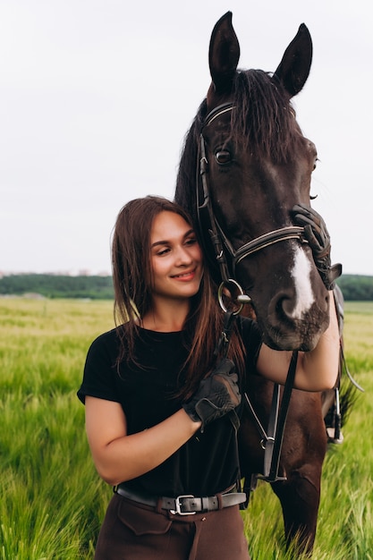 Una ragazza e un giovane cavallo sportivo nella natura