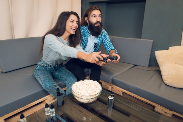 Una ragazza e un ragazzo giocano a una console di gioco.