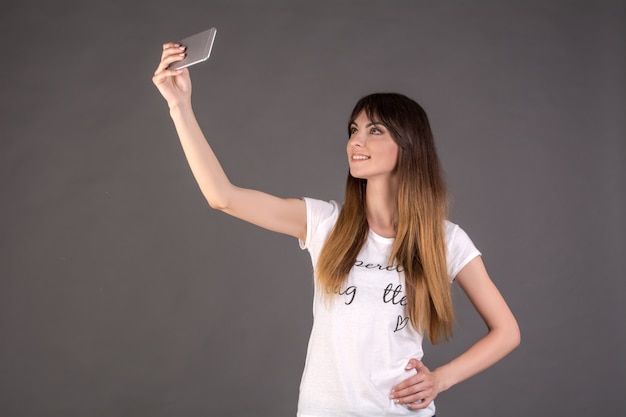 Una ragazza fa un selfie al telefono.