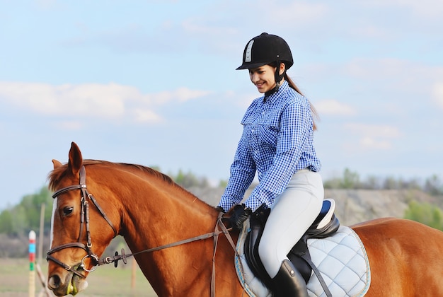 Una ragazza fantino cavalca un cavallo