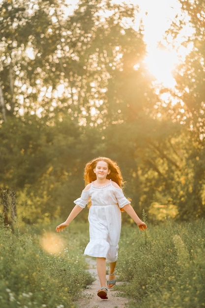 Una ragazza felice corre lungo il sentiero del parco