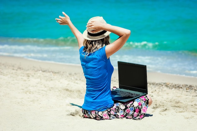 Una ragazza felice dell'uomo con il computer portatile vicino al viaggio di fine settimana al mare