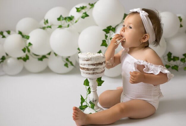 Una ragazza festeggia il suo primo compleanno e mangia una torta di compleanno
