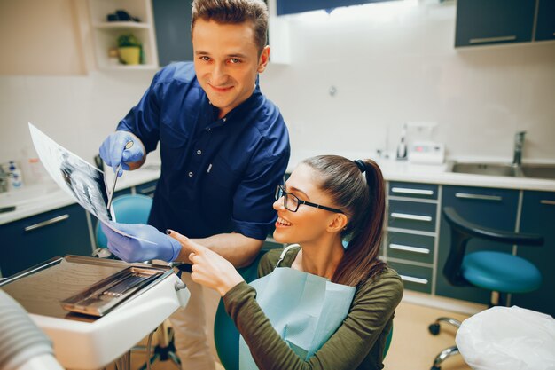 Una ragazza giovane e bella cura i denti con un dentista