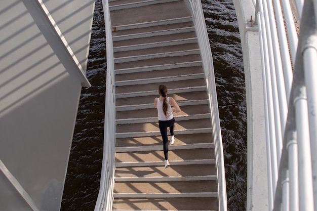 Una ragazza illuminata dal sole corre su per le scale