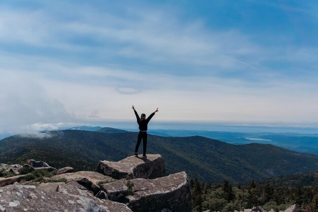 Una ragazza in cima al Monte Pidan guarda una bellissima valle di montagna nella nebbia in estate Viaggi e turismo Escursioni