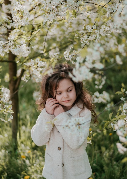 una ragazza in fiore natura un bambino felice fiori di ciliegio fiori bianchi