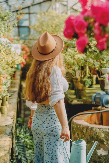 Una ragazza in fiori in una serra con azalee