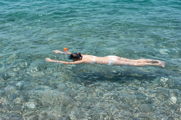 Una ragazza in mare che fa snorkeling Sport acquatico ideale per i bambini Ragazza che fa snorkeling sulla spiaggia