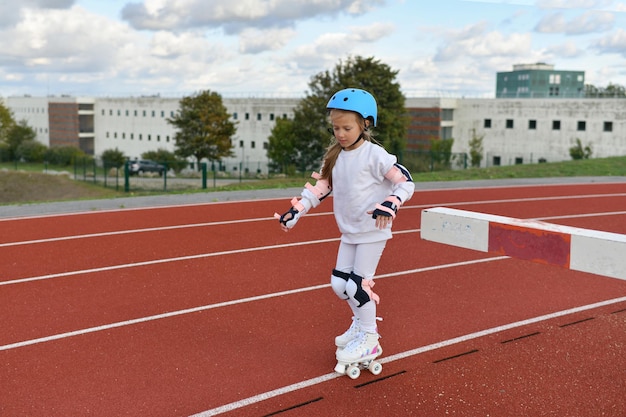 Una ragazza in pattini a rotelle bianchi vintage e un casco allo stadio