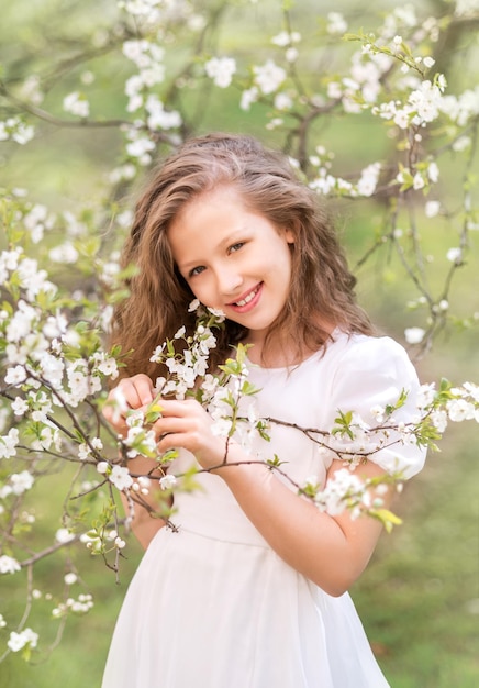 Una ragazza in un abito bianco in un giardino fiorito Giardino di primavera