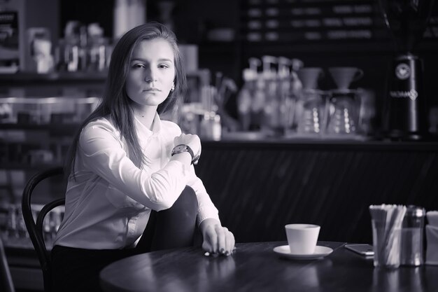 Una ragazza in un bar sta bevendo il caffè Una donna sta facendo colazione in un ristorante Caffè del mattino nella caffetteria per la ragazza