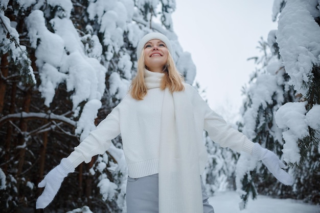 Una ragazza in una foresta d'inverno, bionda, una divertente passeggiata nella natura