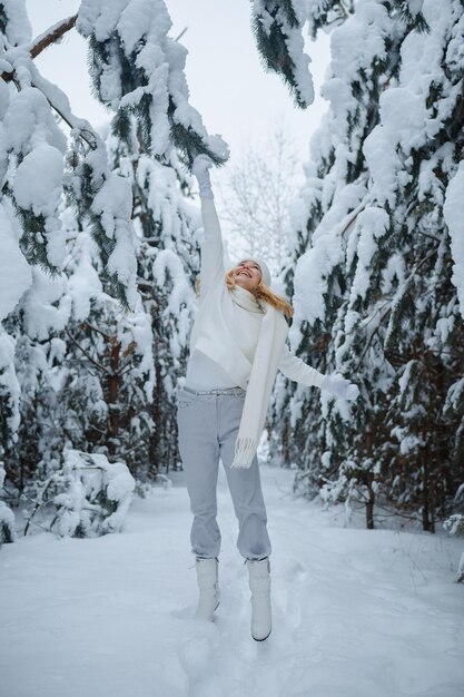 Una ragazza in una foresta d'inverno, bionda, una divertente passeggiata nella natura