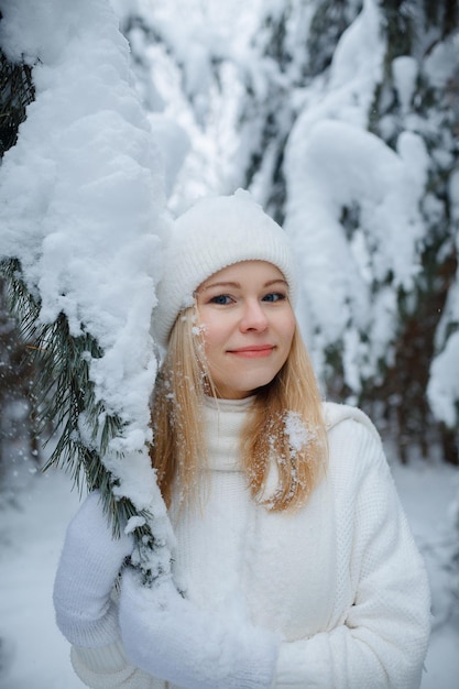 Una ragazza in una foresta d'inverno, bionda, una divertente passeggiata nella natura