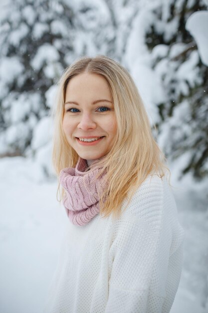 Una ragazza in una foresta d'inverno, bionda, una divertente passeggiata nella natura