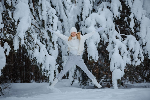 Una ragazza in una foresta d'inverno, bionda, una divertente passeggiata nella natura