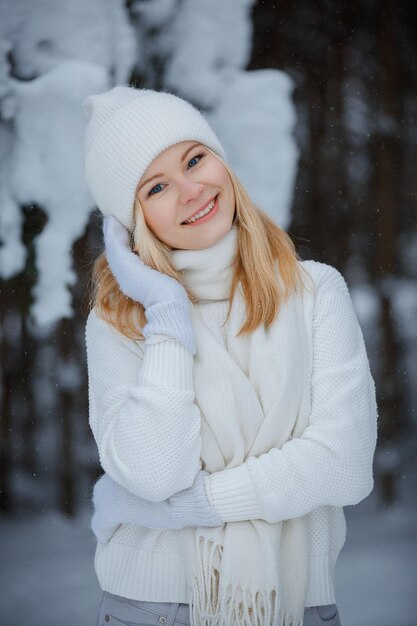 Una ragazza in una foresta d'inverno, bionda, una divertente passeggiata nella natura