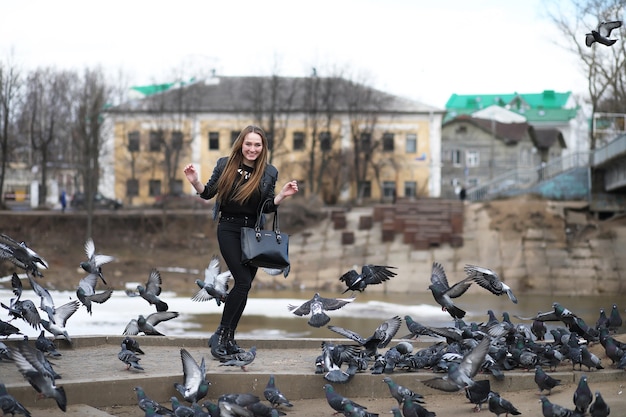 Una ragazza in una passeggiata nel parco e uno stormo di piccioni