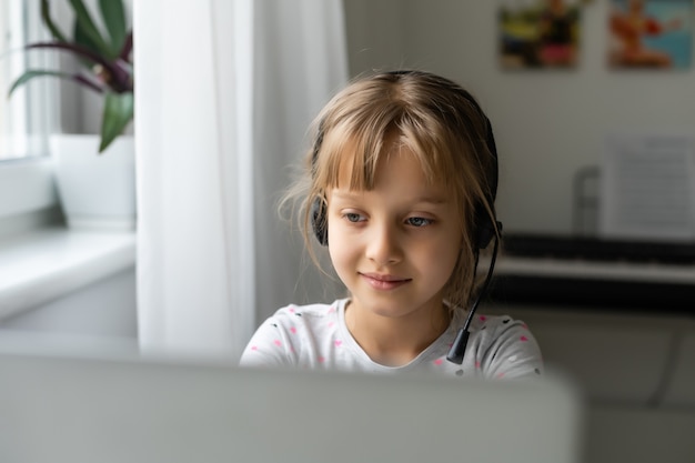 Una ragazza in videoconferenza con una felice insegnante sul computer portatile