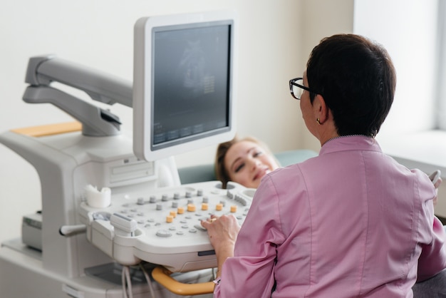 Una ragazza incinta riceve un'ecografia dell'addome in clinica. Visita medica.