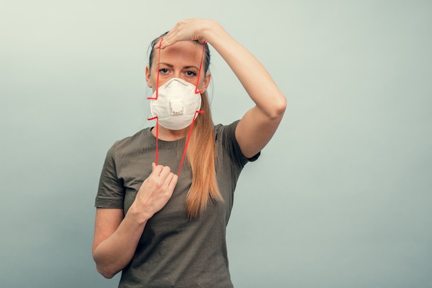 Una ragazza indossa una maschera protettiva. Protezione respiratoria dal coronavirus. Dispositivi di protezione individuale per una pandemia di un'infezione virale. Covid19.