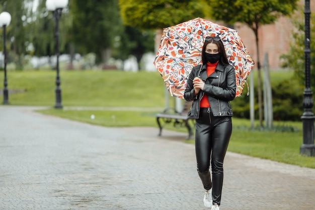 Una ragazza mascherata sta camminando per la strada