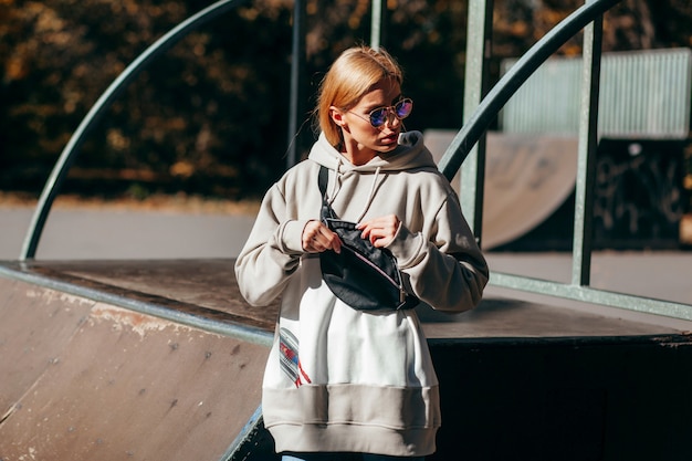 Una ragazza modella alla moda allo skate park