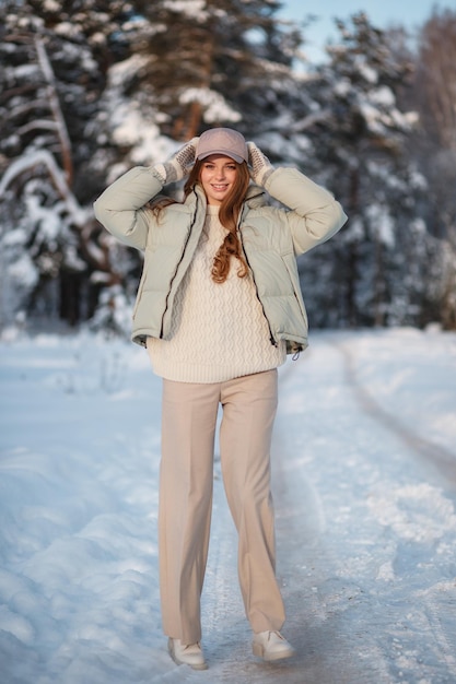 Una ragazza modello che cammina attraverso una foresta innevata una dimostrazione di vestiti